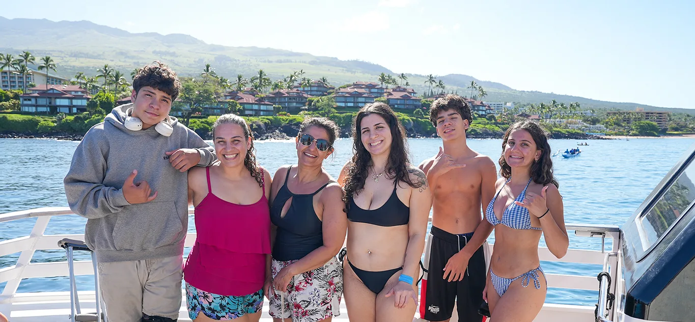 Pride of Maui boat hosting community heroes from Papi's 'Ohana and Maui Food Bank with Maui coastline in background