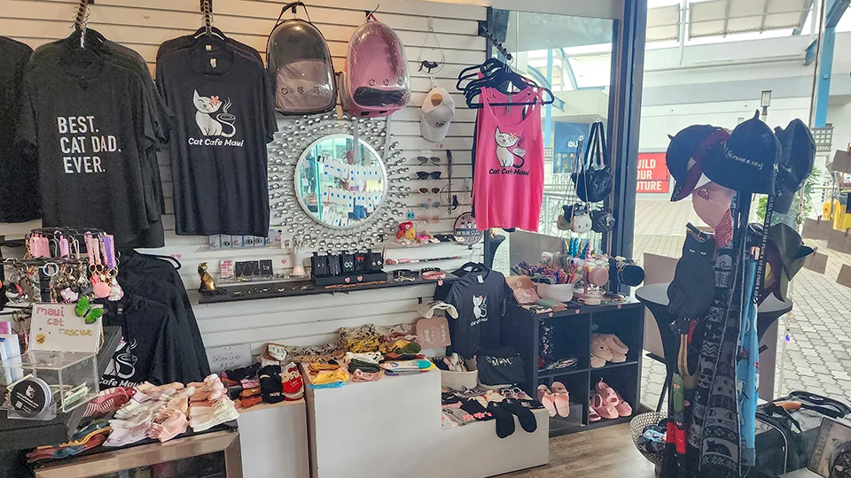 Cat Cafe Maui boutique interior showing Best Cat Dad Ever shirts and locally made cat-themed apparel in Kahului