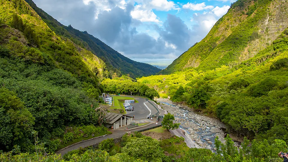 Pathway through ʻĪao Valley surrounded by green mountains.