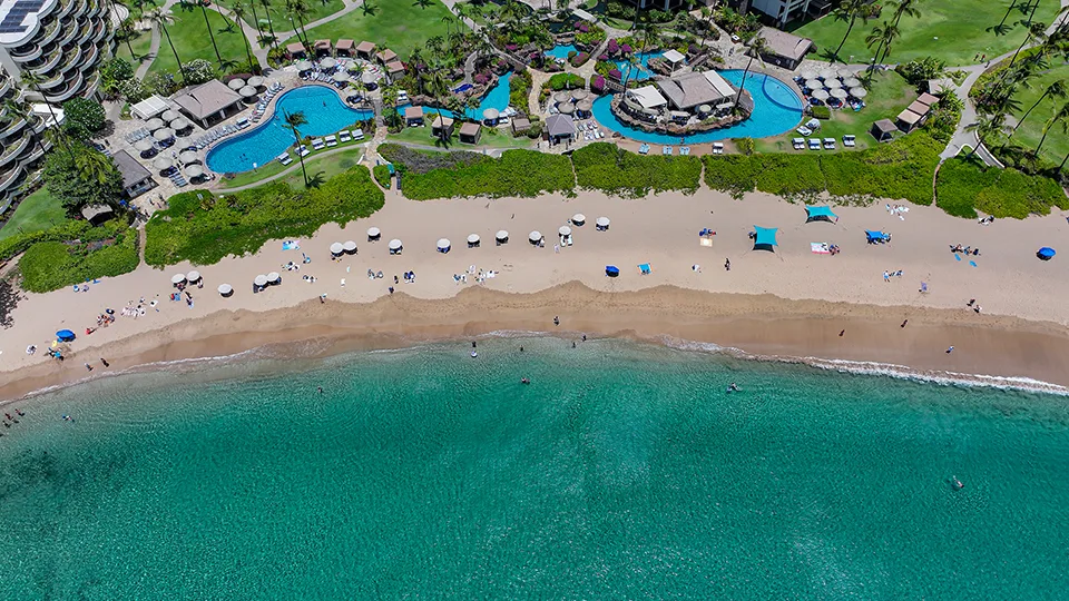 Aerial of Kāʻanapali Beach facing north, showing ocean reef and sandy shoreline.