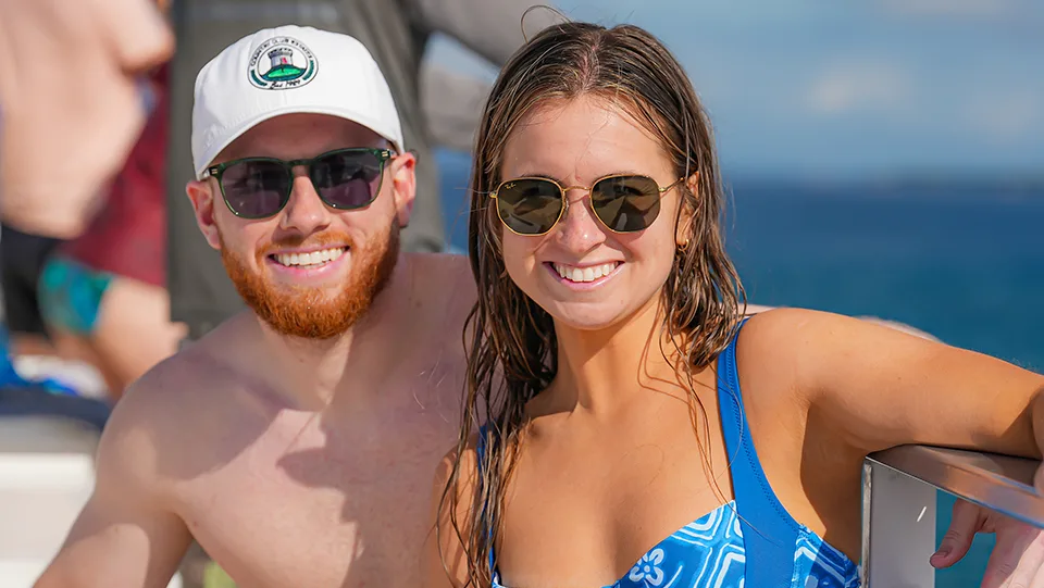 Smiling guests enjoying the deck of the Pride of Maui ʻElua luxury power-catamaran in Maui.