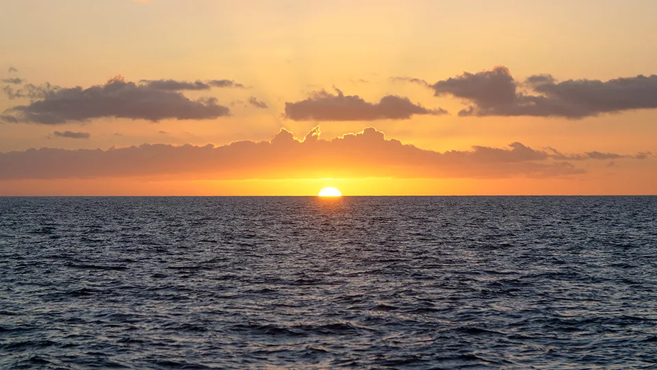 Sun setting directly over the ocean as seen from Poʻolenalena Beach, Maui.