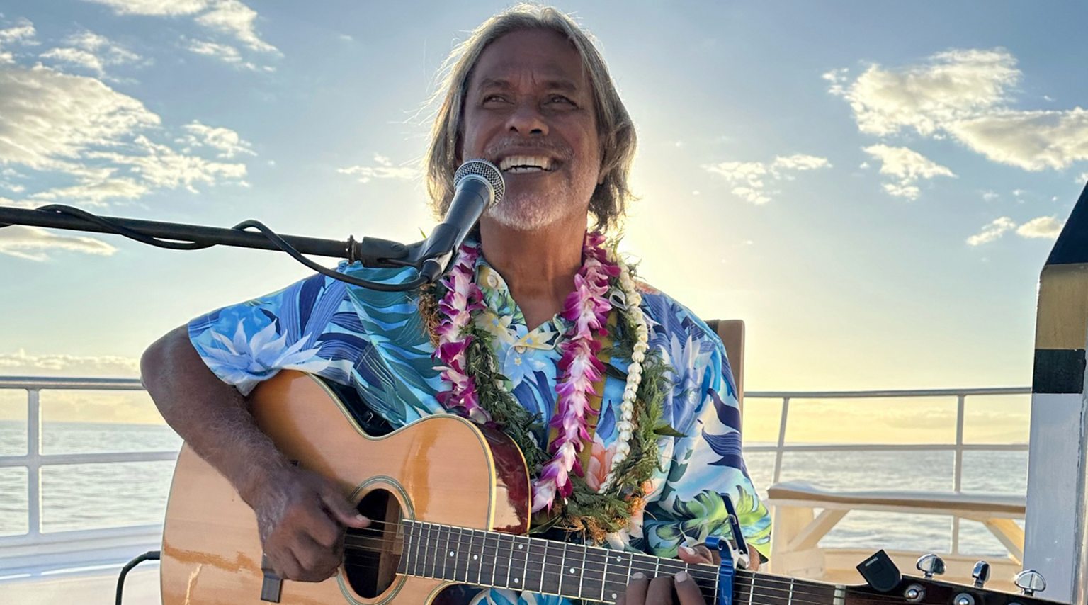 Musician Kekoa performing Hawaiian songs on guitar during the Pride of Maui Sunset Dinner Cruise
