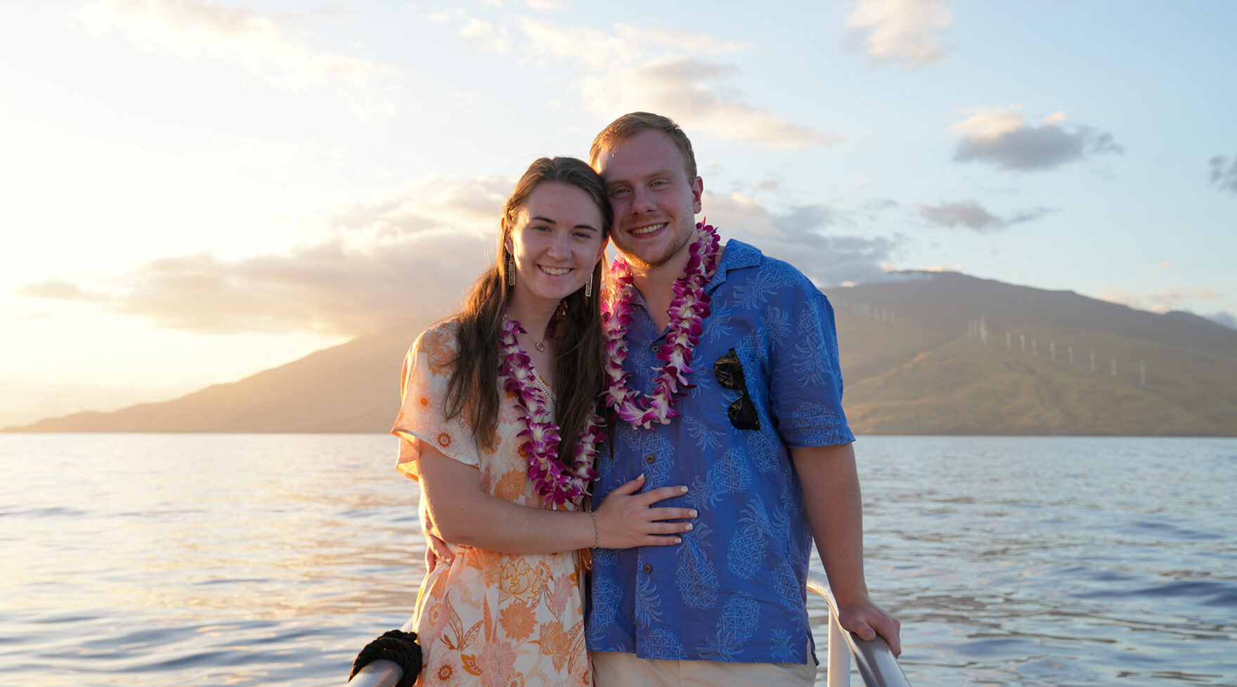 Couple wearing Hawaiian leis enjoying the sunset aboard the Pride of Maui Dinner Cruise