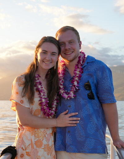 Couple wearing Hawaiian leis enjoying the sunset aboard the Pride of Maui Dinner Cruise