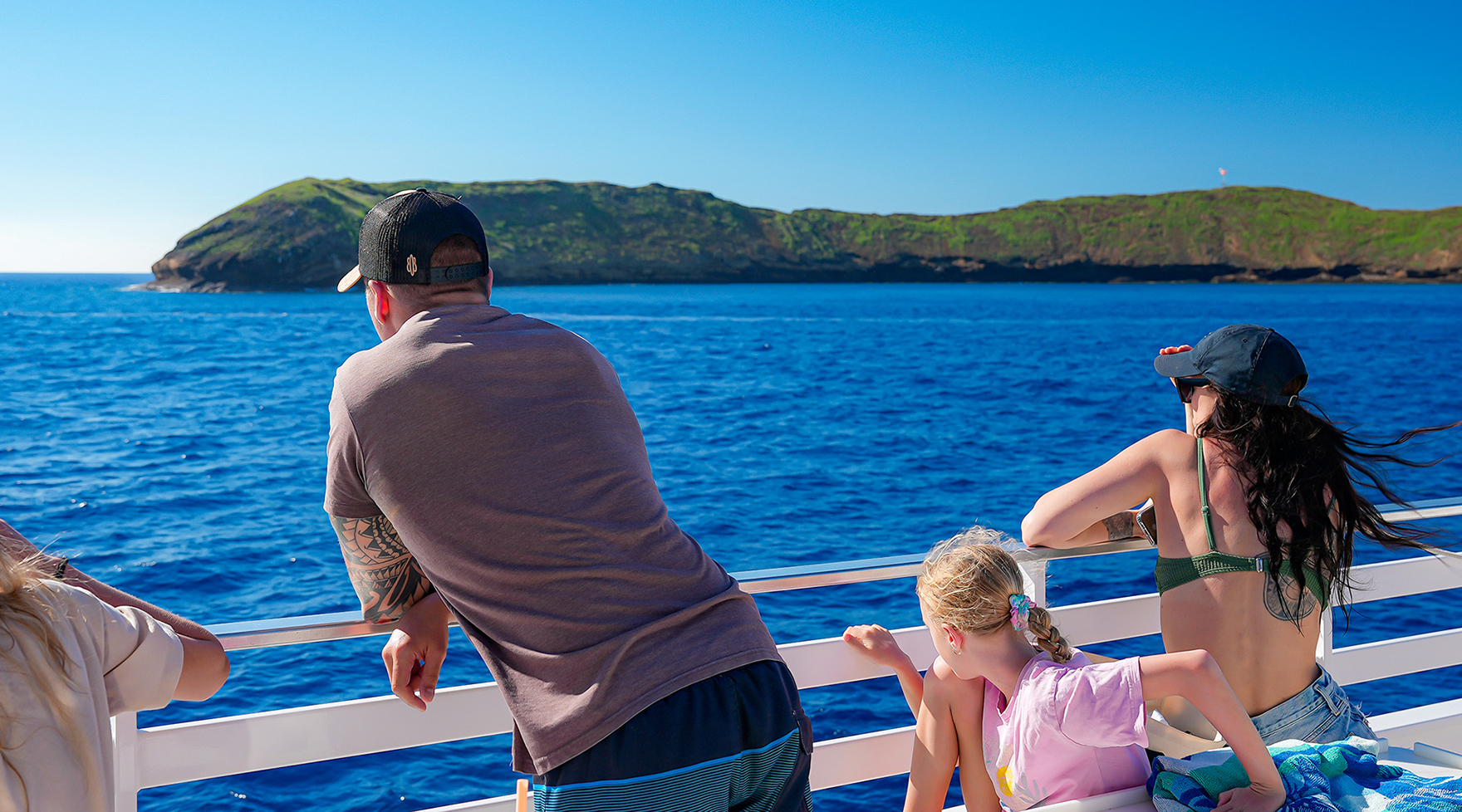 Family watching Molokini from ‘Elua’s rail on a calm morning